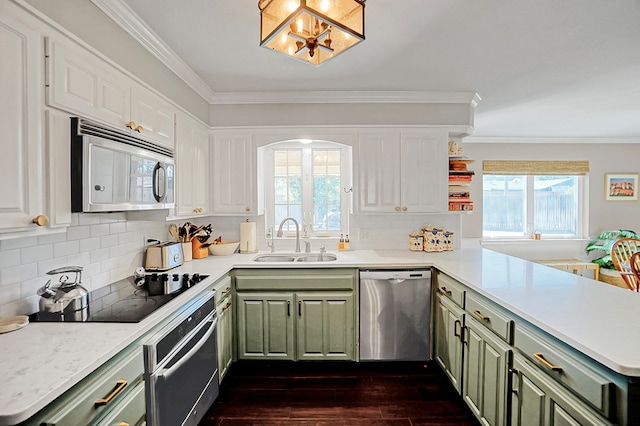 kitchen featuring sink, crown molding, green cabinetry, kitchen peninsula, and stainless steel appliances