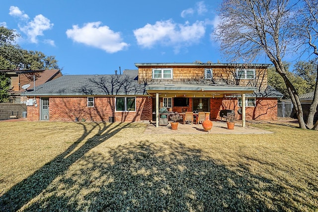 back of property with a yard and a patio area