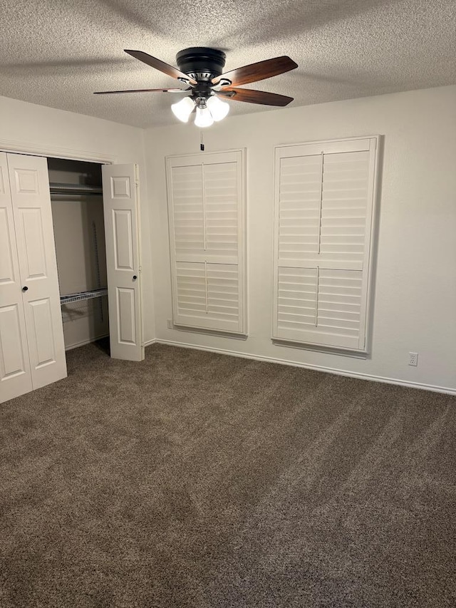 unfurnished bedroom featuring ceiling fan, dark colored carpet, a closet, and a textured ceiling