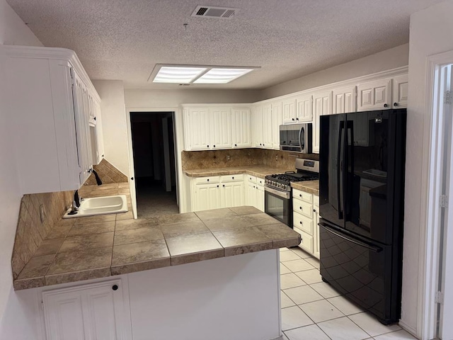 kitchen with light tile patterned floors, visible vents, a peninsula, decorative backsplash, and appliances with stainless steel finishes