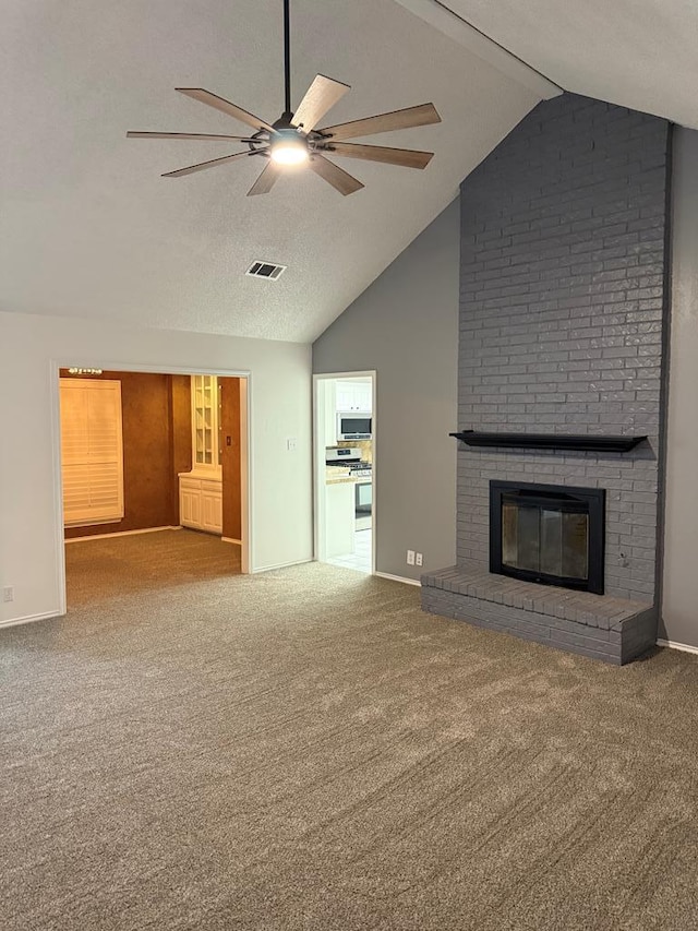 unfurnished living room with visible vents, a brick fireplace, carpet flooring, a textured ceiling, and a ceiling fan