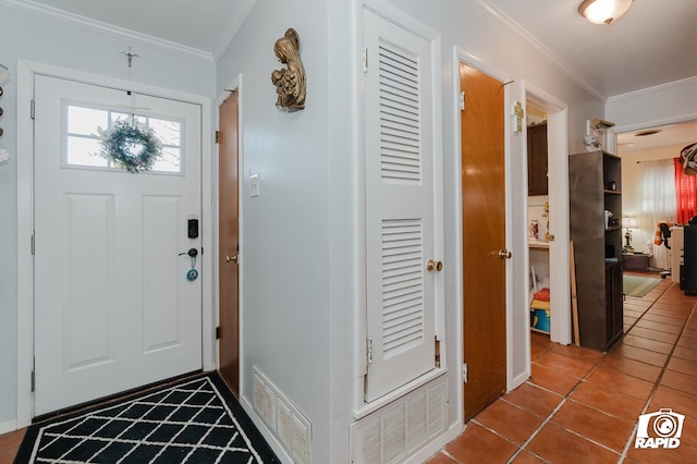 tiled foyer featuring visible vents and crown molding