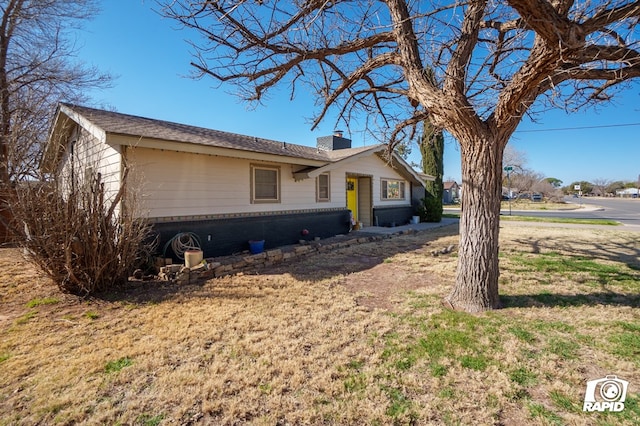 ranch-style home featuring a chimney and a front lawn