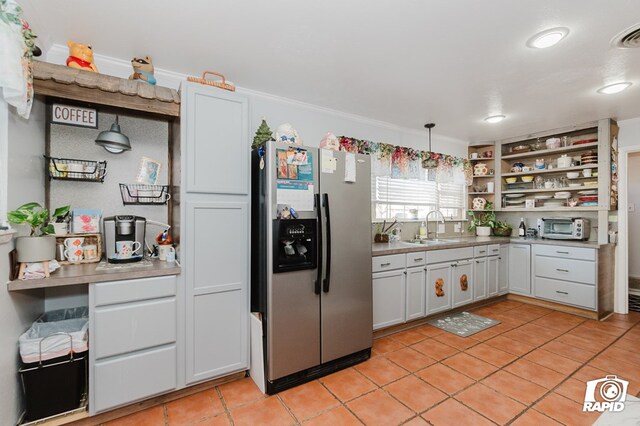 kitchen with light tile patterned floors, a toaster, a sink, stainless steel fridge with ice dispenser, and open shelves