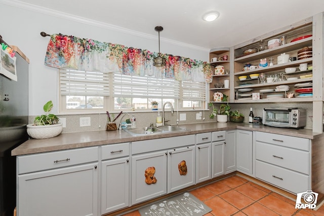 kitchen featuring a toaster, decorative backsplash, freestanding refrigerator, open shelves, and a sink