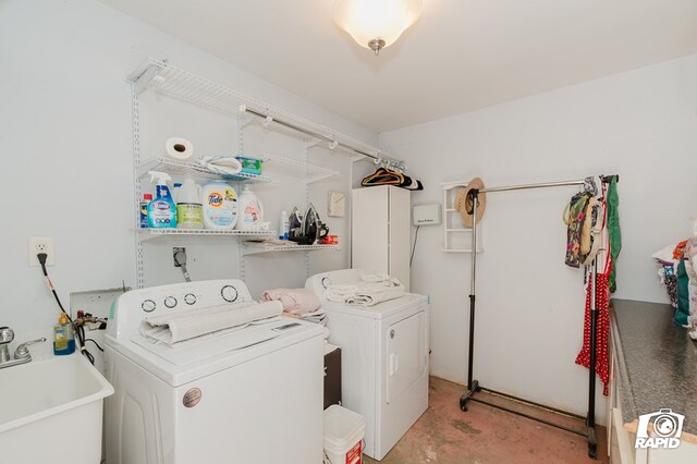 laundry area with laundry area, a sink, and washing machine and clothes dryer