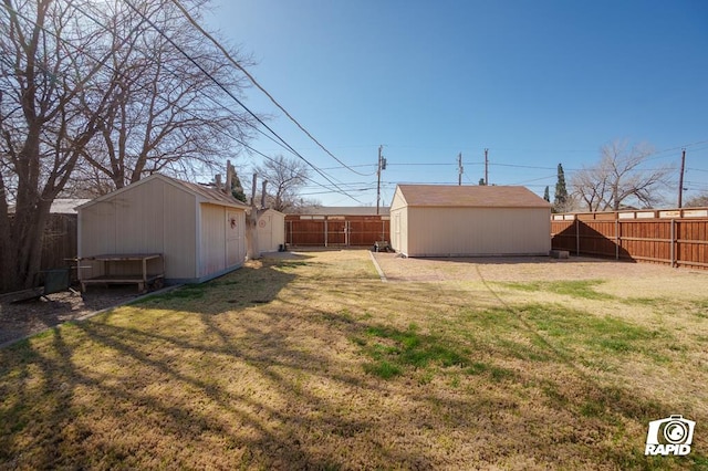 view of yard featuring a fenced backyard, an outbuilding, and a shed