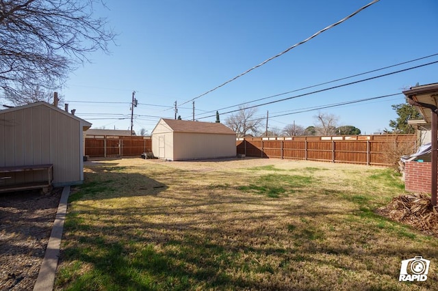 view of yard featuring a storage shed, an outdoor structure, and a fenced backyard