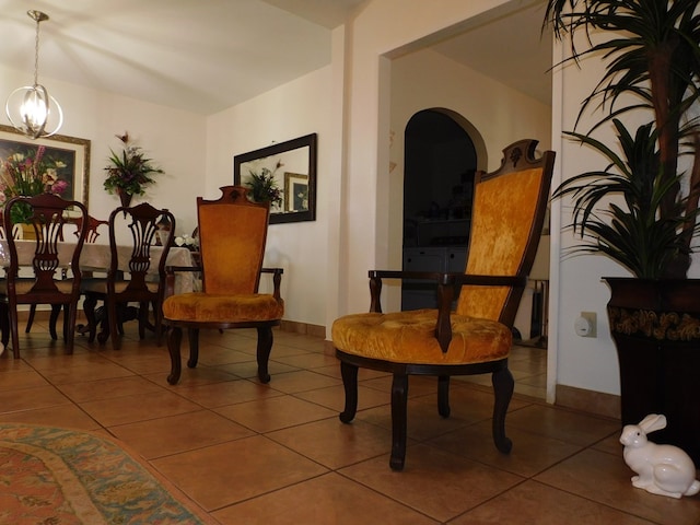 sitting room with an inviting chandelier, tile patterned flooring, and baseboards