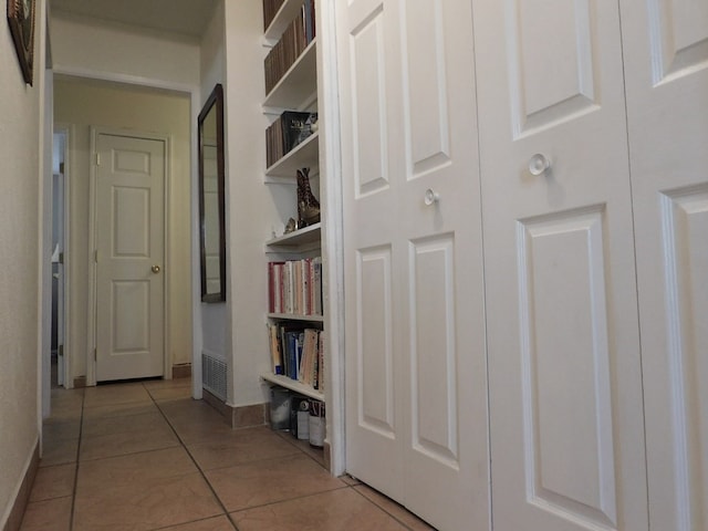 hallway featuring baseboards and light tile patterned floors