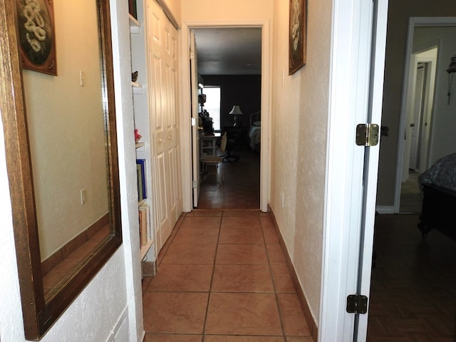 hall with tile patterned flooring and baseboards