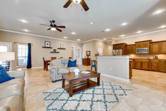 living room with arched walkways, crown molding, and recessed lighting