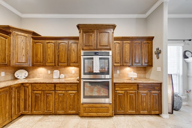 kitchen featuring crown molding, light stone counters, stainless steel double oven, and decorative backsplash