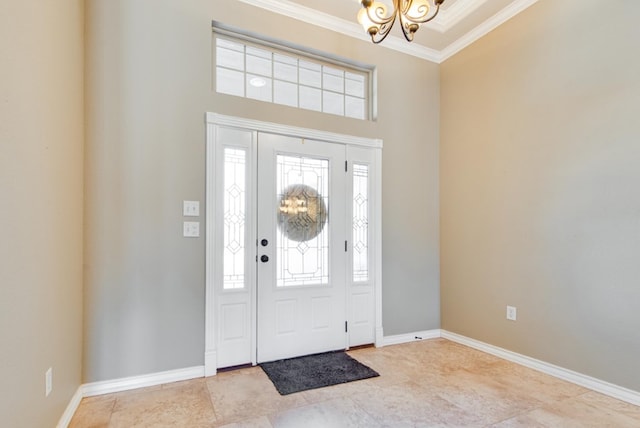 entrance foyer with ornamental molding, a notable chandelier, and baseboards