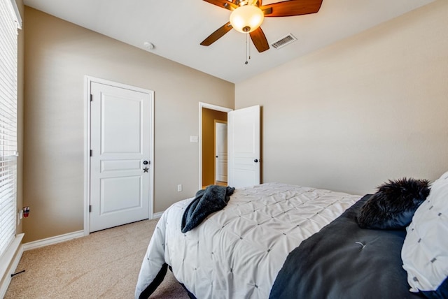 bedroom featuring baseboards, a ceiling fan, visible vents, and light colored carpet