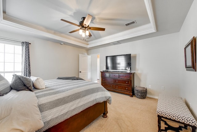 bedroom featuring light carpet, a ceiling fan, visible vents, a raised ceiling, and crown molding