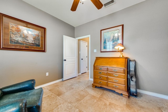 living area featuring baseboards, visible vents, and a ceiling fan