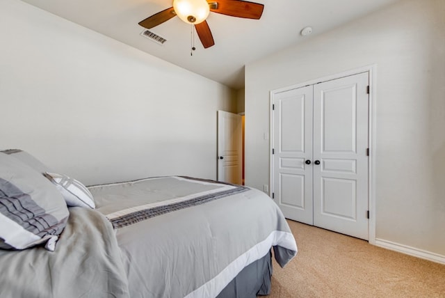 bedroom featuring light carpet, baseboards, visible vents, a ceiling fan, and a closet