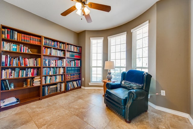 living area featuring ceiling fan and baseboards