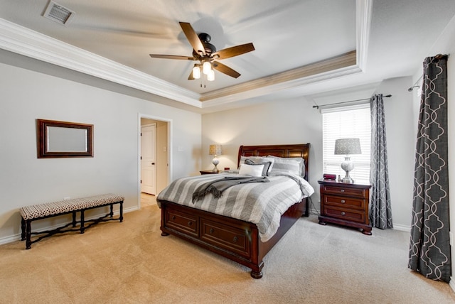 bedroom with ornamental molding, a tray ceiling, light colored carpet, and visible vents