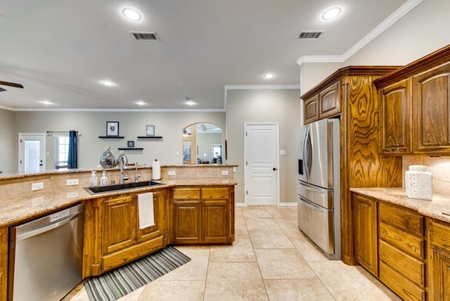 kitchen featuring light stone countertops, visible vents, stainless steel appliances, and a sink