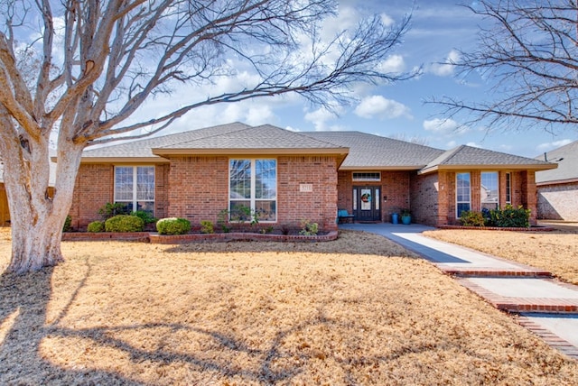 ranch-style home with brick siding and a shingled roof