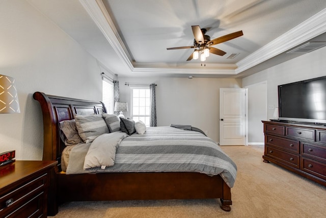 bedroom with visible vents, a tray ceiling, crown molding, and light colored carpet