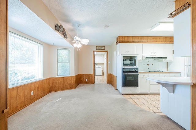 3525 Stanolind Ave, Midland, TX 79707 - kitchen with oven, a textured ceiling, washer / dryer, white cabinetry, and light carpet