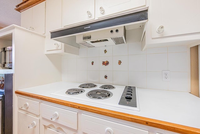 3525 Stanolind Ave, Midland, TX 79707 - kitchen with ventilation hood, white electric stovetop, light countertops, tasteful backsplash, and white cabinets