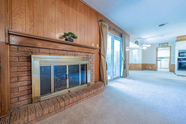 3525 Stanolind Ave, Midland, TX 79707 - unfurnished living room with a glass covered fireplace, carpet flooring, wood walls, a textured ceiling, and wainscoting