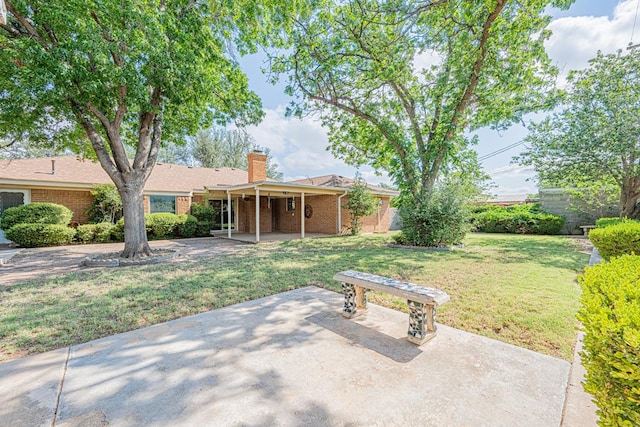 3525 Stanolind Ave, Midland, TX 79707 - rear view of property with a patio area, a chimney, brick siding, and a yard
