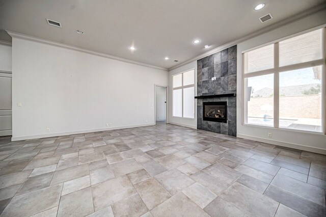 unfurnished living room featuring a tiled fireplace and ornamental molding