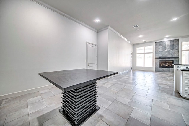 unfurnished living room featuring a tile fireplace and crown molding