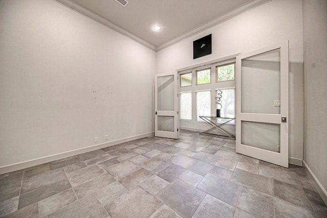 empty room with ornamental molding and french doors