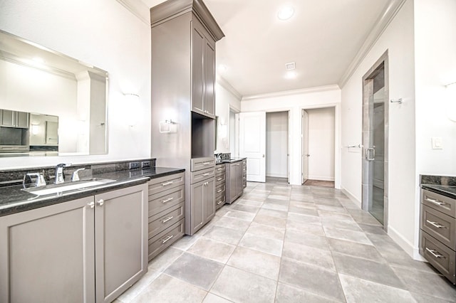 kitchen with light tile patterned flooring, ornamental molding, and sink