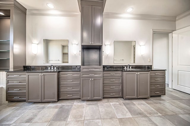 kitchen with gray cabinetry, ornamental molding, and sink