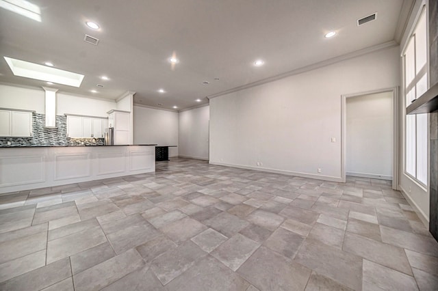 unfurnished living room with crown molding