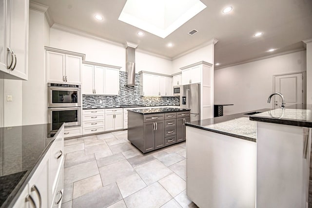 kitchen with dark stone countertops, sink, a kitchen island, and stainless steel appliances