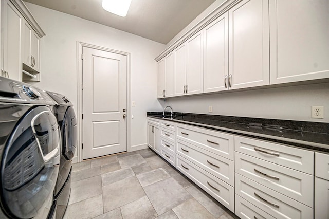 washroom with cabinets, sink, and washing machine and clothes dryer