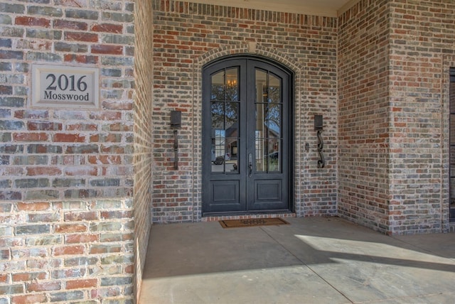 view of exterior entry featuring brick siding