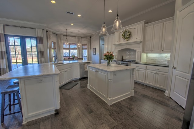 kitchen with crown molding, a spacious island, white cabinets, a sink, and dishwasher