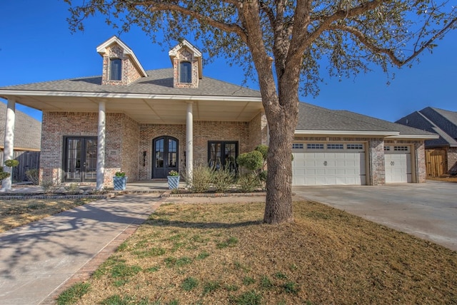 view of front of house featuring french doors, an attached garage, and brick siding