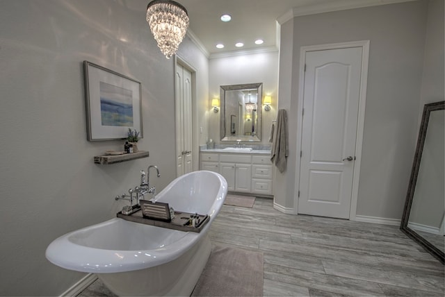 full bathroom featuring a soaking tub, ornamental molding, wood tiled floor, vanity, and baseboards