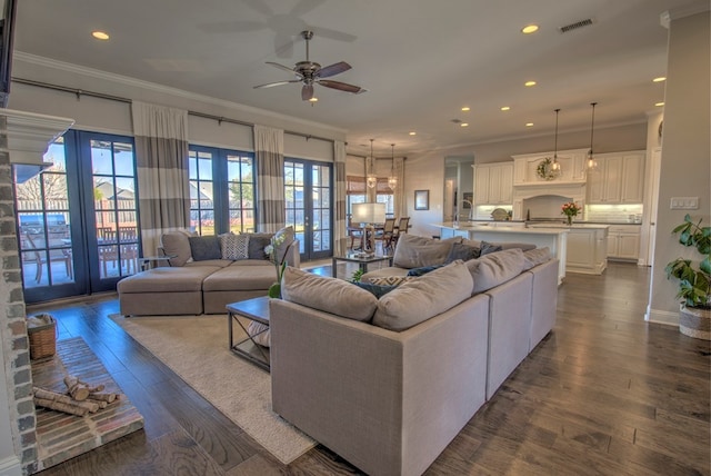 living area featuring visible vents, ornamental molding, dark wood-type flooring, and recessed lighting