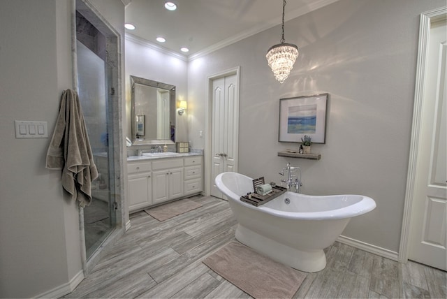 bathroom featuring wood finish floors, crown molding, a stall shower, vanity, and a freestanding tub