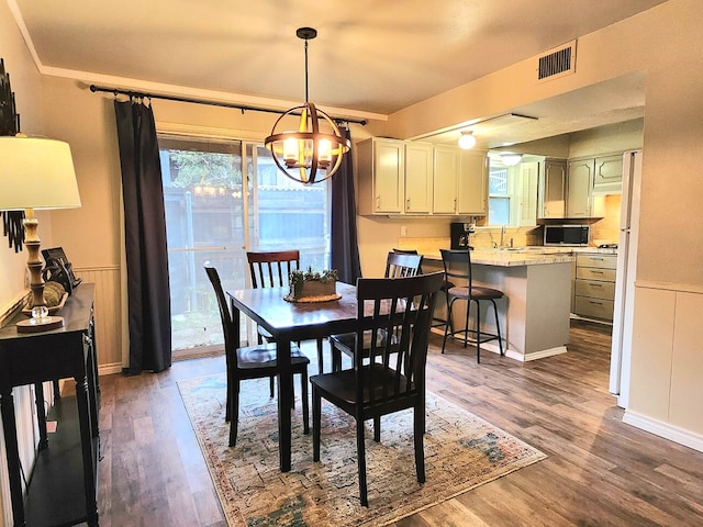 501 W Scharbauer Dr Unit 30, Midland, TX 79705 - dining area featuring a wainscoted wall, visible vents, wood finished floors, and a chandelier