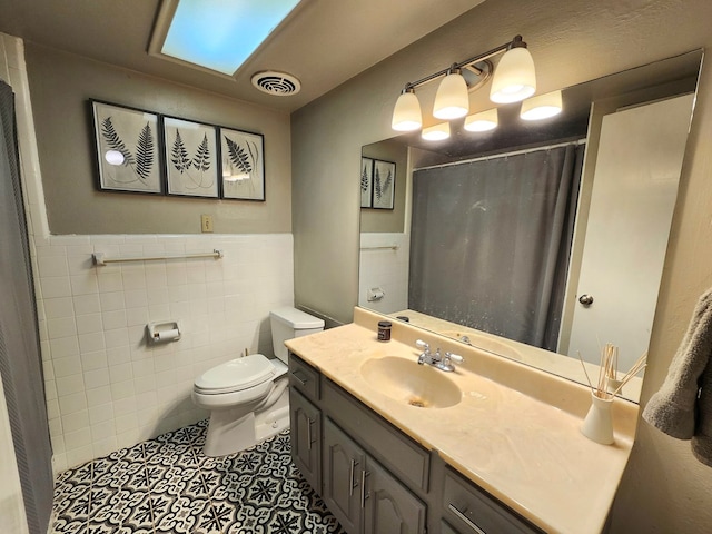 501 W Scharbauer Dr Unit 30, Midland, TX 79705 - full bathroom with tile walls, a wainscoted wall, visible vents, toilet, and tile patterned flooring