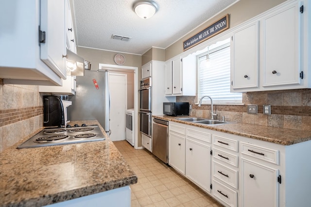 3702 W Michigan Ave, Midland, TX 79703 - kitchen with appliances with stainless steel finishes, white cabinets, a textured ceiling, backsplash, and light floors