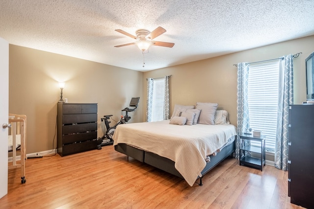 3702 W Michigan Ave, Midland, TX 79703 - bedroom with light wood-type flooring, a textured ceiling, and a ceiling fan
