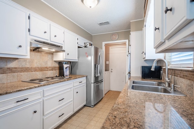 3702 W Michigan Ave, Midland, TX 79703 - kitchen featuring under cabinet range hood, electric cooktop, stainless steel fridge with ice dispenser, white cabinets, and decorative backsplash
